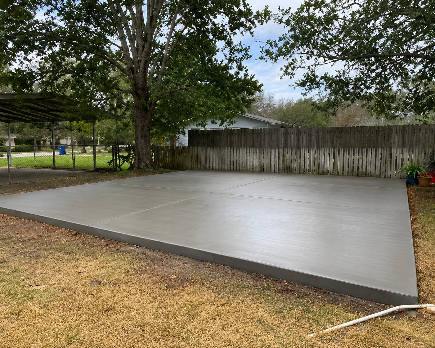 Finished concrete patio slab with smooth trowel finish and control joints in residential yard